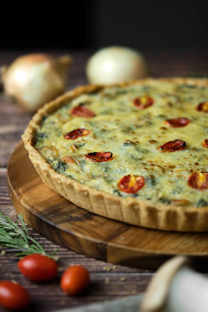 istock Homemade cheesy spinach quiche for brunch. set on wooden cafe table background. 1277481003