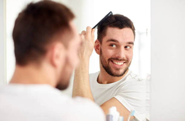 istock happy man brushing hair  with comb at bathroom 1277481780