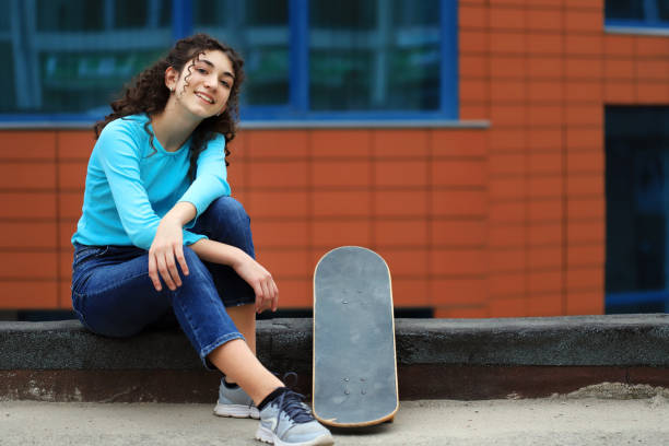 istock Girl sitting next to her skateboard 1277482869