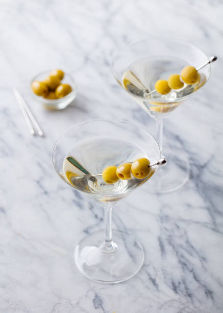 istock Martini cocktail with green olives on marble table background. Close up. 1277482987