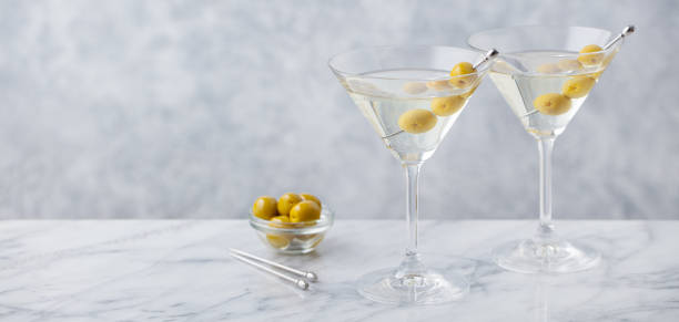 istock Martini cocktail with green olives on marble table background. Copy space. Close up. 1277483038