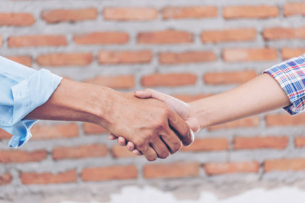 istock Civil Construction engineer teams shaking hands together wear work helmets worker on construction site. Foreman industry project working engineer teamwork. Two asian engineer team shake hands together 1277487091