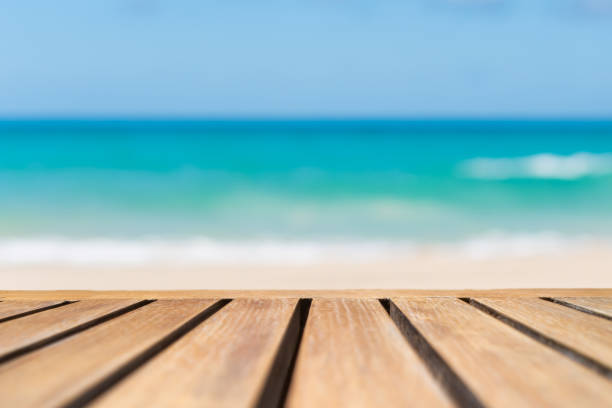 istock Selective focus of old wood table with blur beautiful beach background for display your product. 1277490942
