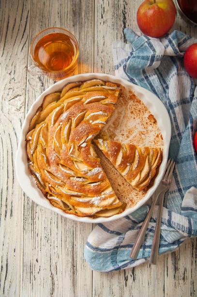 Heap of homemade apple pie close-up and copy space. A quick autumn dessert idea with tea. Autumn pie with apples, Rustic wooden background.