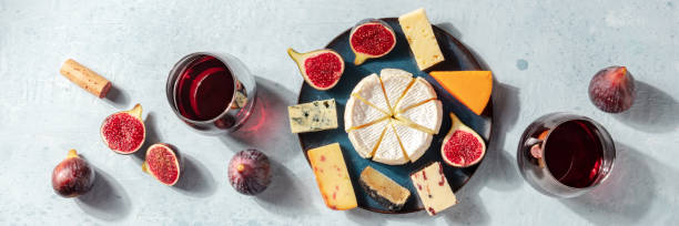 Cheese panorama. Various cheeses with wine and figs, a flat lay Cheese panorama. Various cheeses with wine and figs, a flat lay, top shot plate fig blue cheese cheese stock pictures, royalty-free photos & images