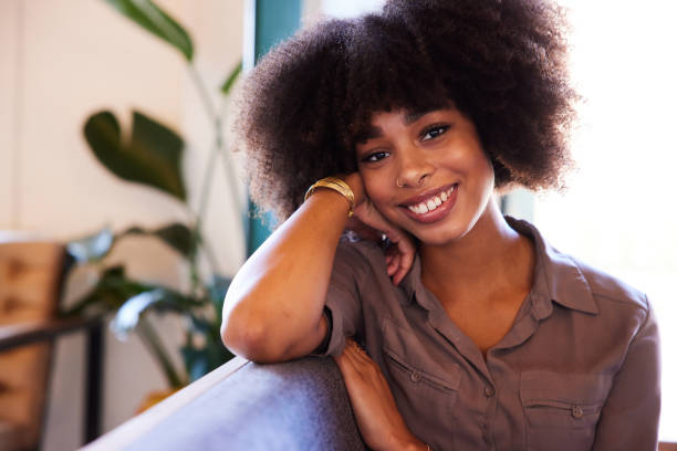 istock Smiling young woman sitting on a cafe sofa 1277497153