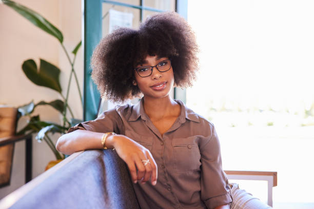 istock Confident young woman sitting on a cafe sofa 1277497800