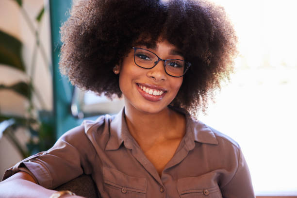 istock Young woman sitting on a sofa and smiling 1277498539