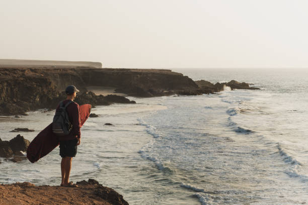 istock Young adult caucasian surfer watching waves standing on a cliff 1277499512