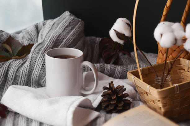 istock Cozy home decor with a warm atmosphere. White mug with hot tea and knitted clothes 1277499524