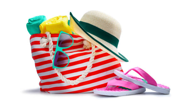 Striped red white beach bag with towel sunglasses flip-flops and hat isolated on white Striped red white beach bag with towel sunglasses flip-flops and hat isolated on white background flip flop sandal beach isolated stock pictures, royalty-free photos & images