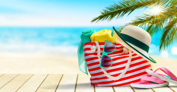 istock Beach bag, flip flops, hat and sunglasses on a tropical beach. 1277500381