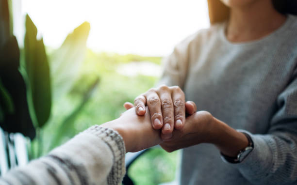 istock Women holding each other hands for comfort 1277500388