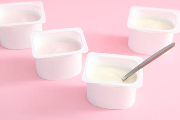 istock Tasty yogurt in a plastic glass on a colored table top view. Place to insert text. Useful snack. 1277503367