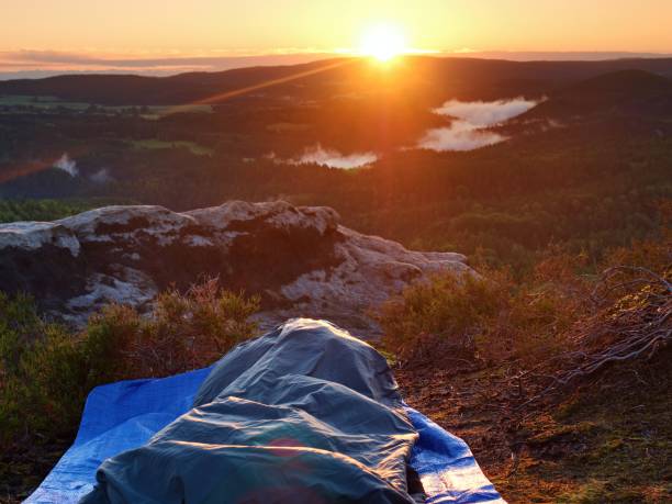 istock Beautiful Awakening In Sleeping Bag On A Rock Ledge. Birds Are Singing In Forest With Clouds Of Mist 1277504315
