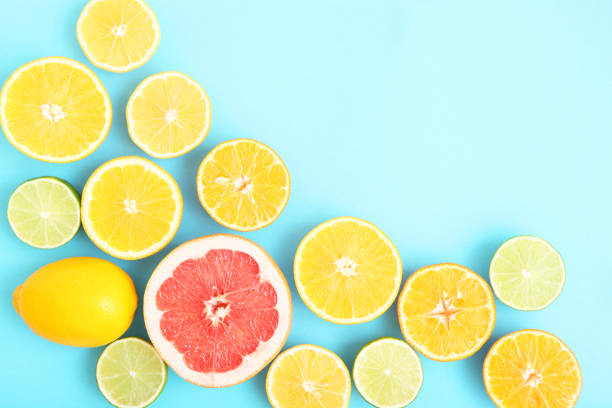 istock Different citrus and juicy slices on a colored background top view. Place to insert text. 1277504343