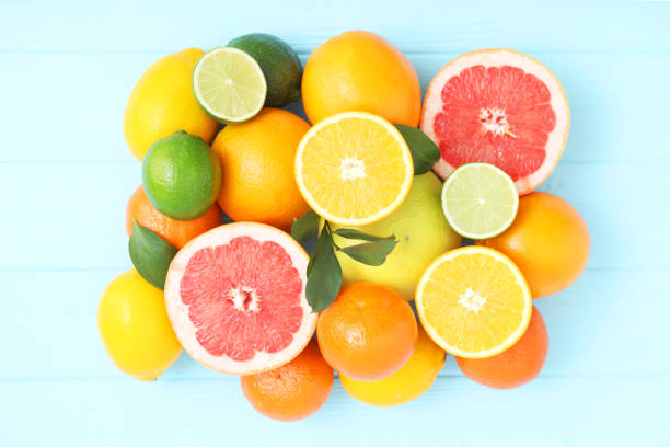 istock Different citrus and juicy slices on a colored background top view. Place to insert text. 1277505233