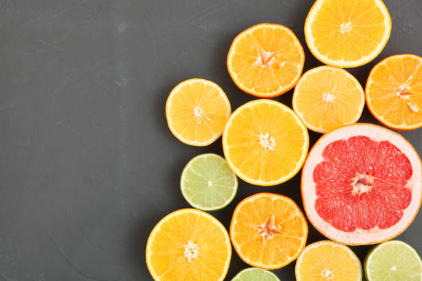 istock Different citrus and juicy slices on a colored background top view. Place to insert text. 1277505840