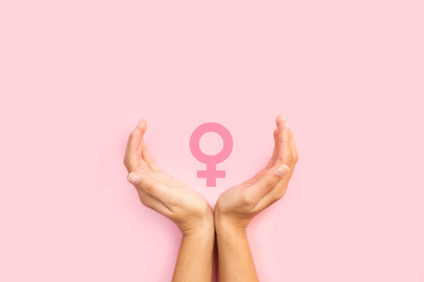 Woman hands protecting female sign Woman hands protecting female sign on a pink background womens issues photos stock pictures, royalty-free photos & images