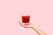 Woman hand holding a glass of red vermouth