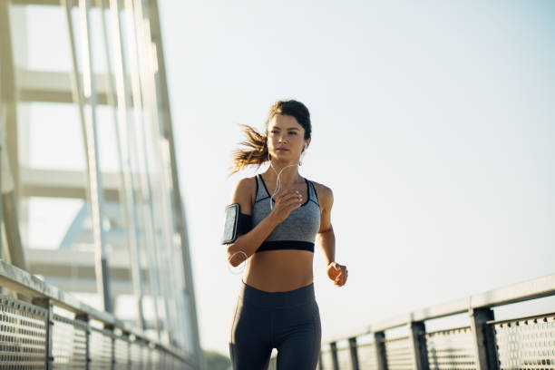 istock Female jogger running over the bridge 1277508486