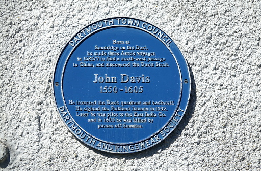 Dartmouth England. July 2020. Blue wall plaque in memory of John Davis on white wall. He discovered the Davis strait while searching for North West passage to China. Invented Quadrant and backstaff