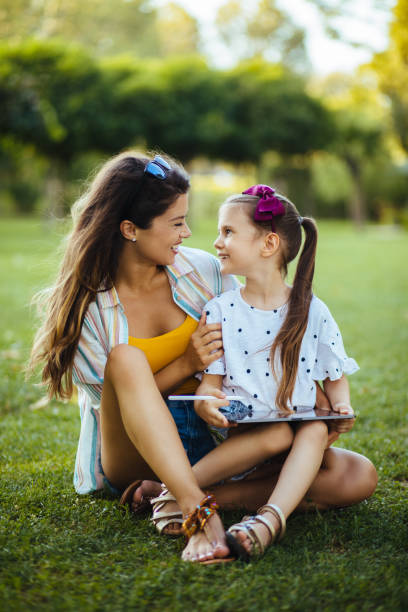 istock Mother and daughter using digital tablet in the park 1277509053