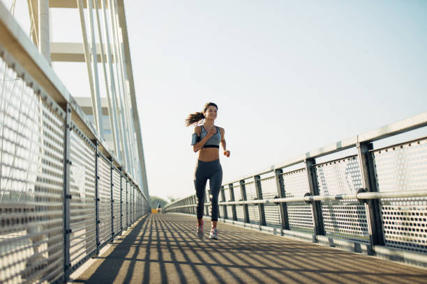 istock Female jogger running over the bridge 1277509088