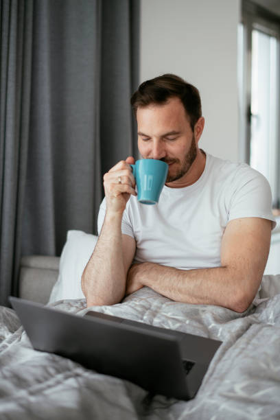 istock Young man watching movie in bed. 1277509558