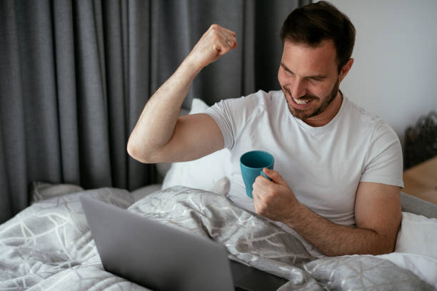 istock Young man watching movie in bed. 1277509563