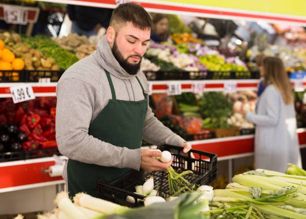 istock Market worker puts onions on the counter 1277511327