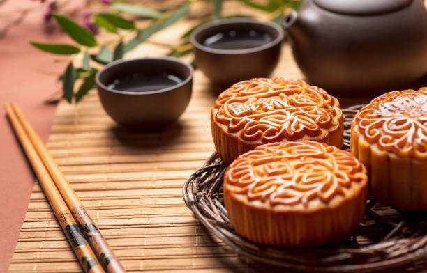 月餅の伝統的な中国のペストリーは、真秋の日のお祭りのためにお茶と一緒に提供 - afternoon tea 写真 ストックフォトと画像