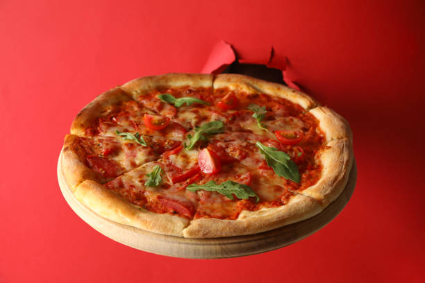 istock Hand hold box with tasty pizza on red background 1277515105