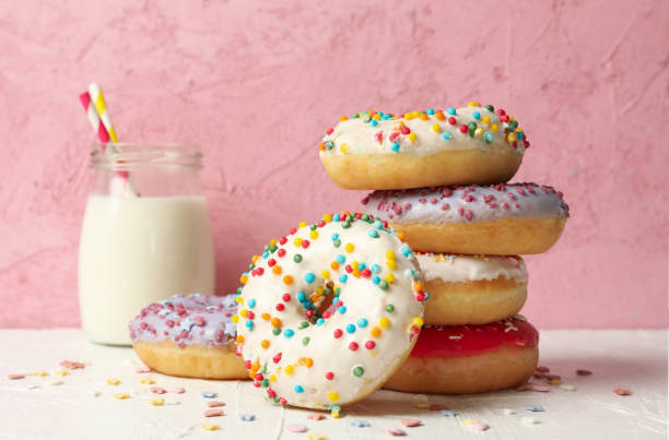 istock Milk and tasty donuts against pink background 1277516670