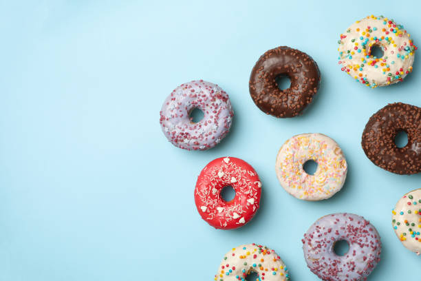 istock Flat lay with tasty donuts on blue background 1277516776