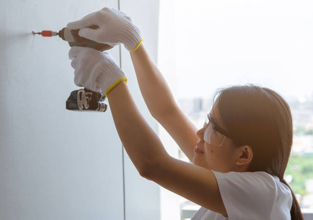 아시아 여성, 무선 드릴로 아파트 벽으로 나사 를 시추합니다. 여성은 아파트 리노베이션을 위해 안전 안경과 손 잡고 드릴링 도구를 착용합니다. diy 컨셉으로 집 을 개선하는 여성. - home improvement drill house repairing 뉴스 사진 이미지