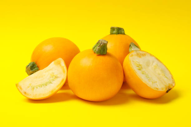 istock Bunch of round zucchini on yellow background 1277517202