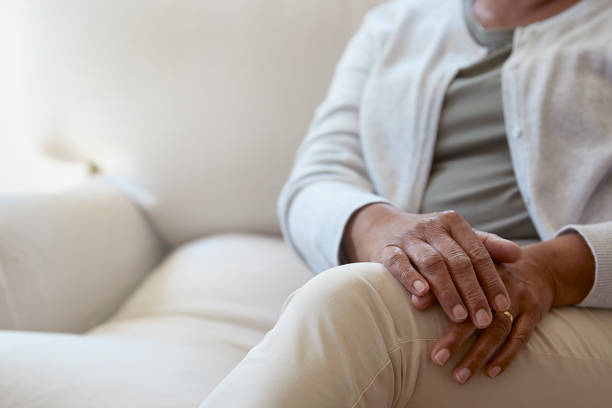 istock Senior woman sitting on sofa focus on hands 1277518662