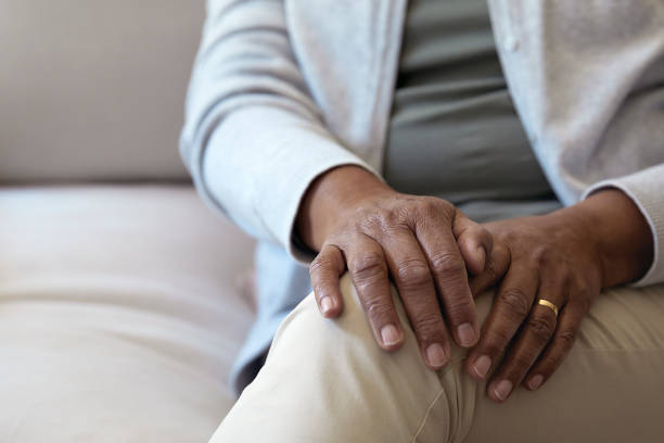 istock Senior woman sitting on sofa focus on hands 1277518838
