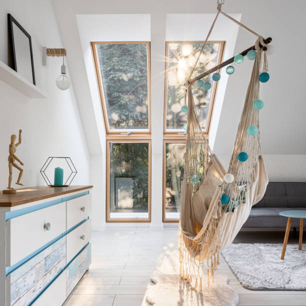 istock Stylish attic room with hammock seat 1277518973