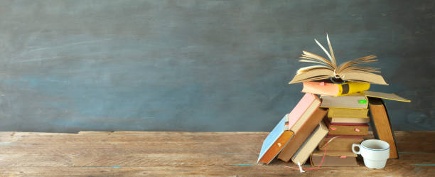 istock Stack of books and open book. Reading,literature,education,library,home office concept, panoramic large copy space 1277519820
