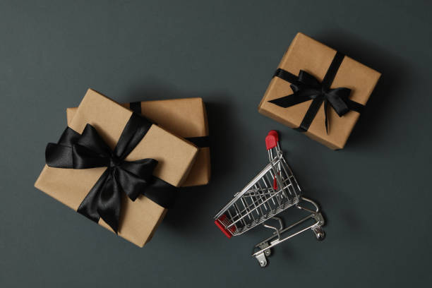 istock Gift boxes and shop trolley on gray background 1277519944