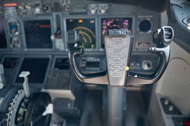 Airplane cockpit with control column and flight displays Aircraft flight deck with yoke or control wheel and instrument panel on blurred background yoke stock pictures, royalty-free photos & images