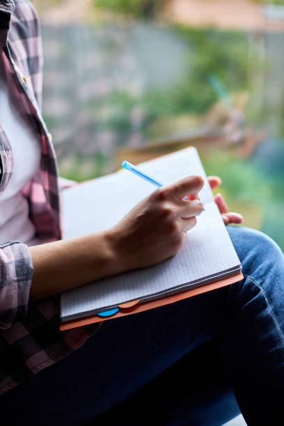 istock Woman, sitting at window at home, writes in notebook goals 1277522140
