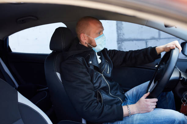 istock Man with protective mask adriving a car by Coronavirus pandemic quarantine 1277522149