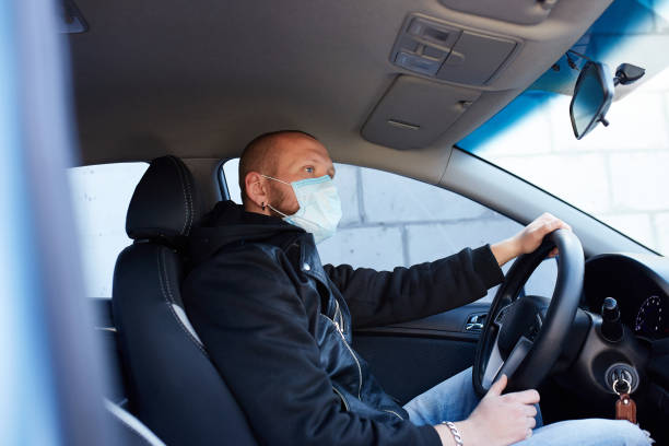istock Man with protective mask adriving a car by Coronavirus pandemic quarantine 1277522668