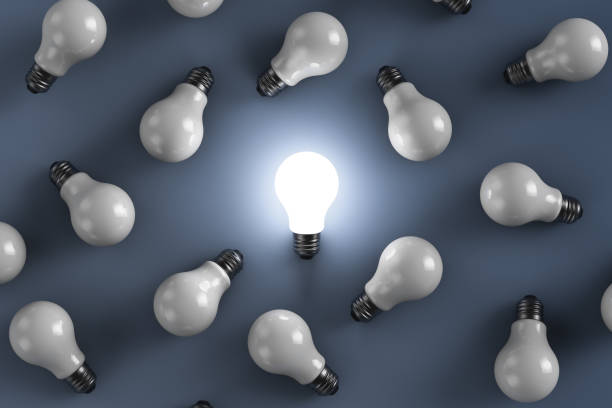 istock Light bulbs lie chaotically on the surface. One of them glows. 1277526327