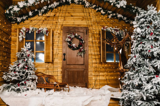 piękny dom urządzony na boże narodzenie i nowy rok. ozdoba świąteczna na drzwiach. choinka, wystrój i sanki w pobliżu domu. - new year wall door decoration zdjęcia i obrazy z banku zdjęć