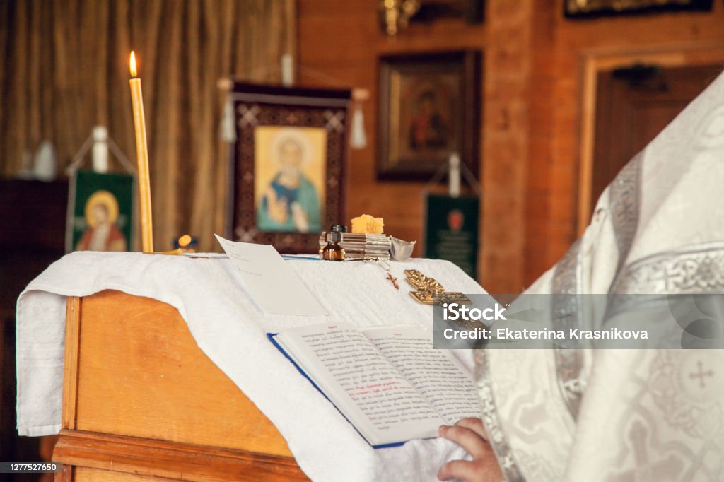 Ein Priester hält ein Buch zum Lesen von Gebeten während des Taufesus in der orthodoxen Kirche - Lizenzfrei Achtsamkeit - Persönlichkeitseigenschaft Stock-Foto