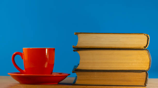 istock red cup with coffee and three old books lie on an oak table. 1277527865